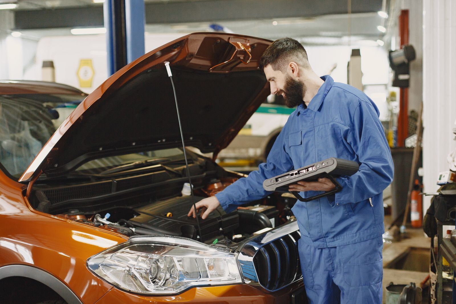 Technician running a diagnostic scan on a car in the workshop